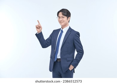 A young and handsome Asian man in a suit is wearing glasses and making various facial expressions and hand gestures. - Powered by Shutterstock