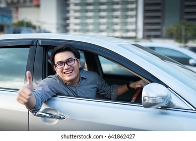 Young Handsome Asian Man Thumps-up In Car