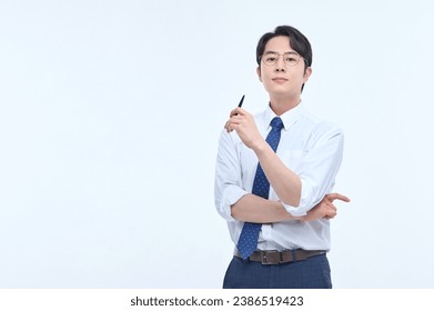 A young, handsome Asian man wearing glasses and a dress shirt and tie is holding a pen and explaining about business. - Powered by Shutterstock