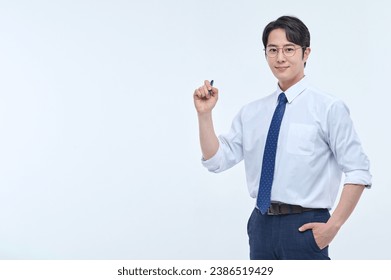 A young, handsome Asian man wearing glasses and a dress shirt and tie is holding a pen and explaining about business. - Powered by Shutterstock