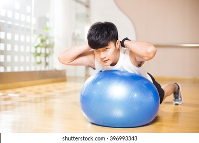 Young Handsome Asian Man Works Out In Modern Gym