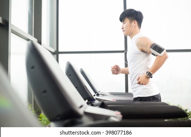 Young Handsome Asian Man Works Out In Modern Gym