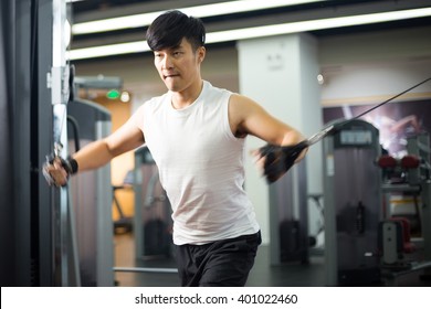 Young Handsome Asian Man Works Out In Modern Gym