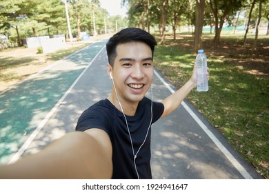Young handsome Asian men selfie looking at the camera and walking exercise in the park