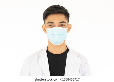 A Young And Handsome Asian Teen Man Wearing The Protective Hygiene Mask On Face And Looking To Camera On White Background. Idea For Safety And Health Care During Coronavirus Spreading.