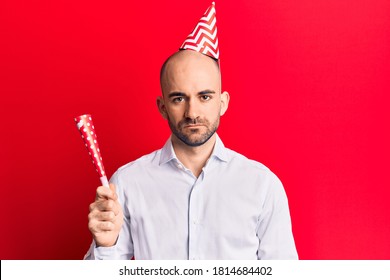 Young Handsome Bald Man Wearing Party Hat And Trumpet Thinking Attitude And Sober Expression Looking Self Confident 