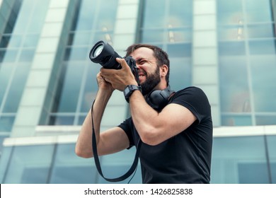 Young handsome beard man in white shirt and trousers makes beautiful pictures on film retro camera, stylishly dressed, photographer,outdoor portrait, close up,brutal, tattoo, street photo,photographer - Shutterstock ID 1426825838
