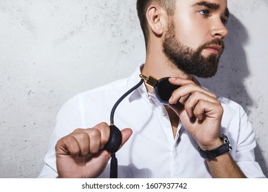 Young And Handsome Bearded Man Is Using Atomizer Nozzle With Perfume