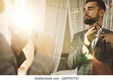 Young And Handsome Bearded Man Is Using Atomizer Nozzle With Perfume