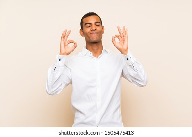 Young Handsome Brunette Man Over Isolated Background In Zen Pose