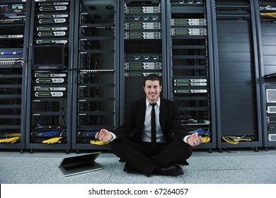 young handsome business man in black suit and tie practice yoga and relax at network server room while representing stres control concept - Powered by Shutterstock