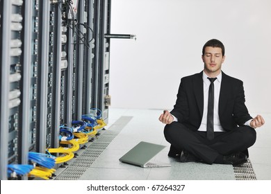 young handsome business man in black suit and tie practice yoga and relax at network server room while representing stres control concept - Powered by Shutterstock