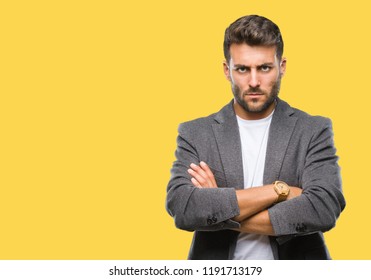 Young handsome business man over isolated background skeptic and nervous, disapproving expression on face with crossed arms. Negative person.