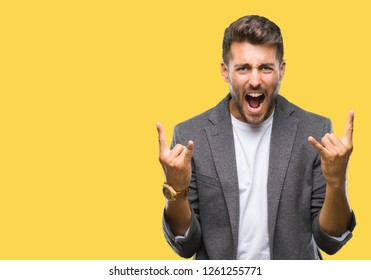 Young Handsome Business Man Over Isolated Background Shouting With Crazy Expression Doing Rock Symbol With Hands Up. Music Star. Heavy Concept.