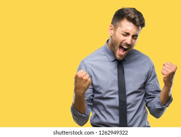 Young Handsome Business Man Over Isolated Background Very Happy And Excited Doing Winner Gesture With Arms Raised, Smiling And Screaming For Success. Celebration Concept.