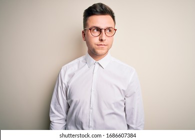 Young Handsome Business Mas Wearing Glasses And Elegant Shirt Over Isolated Background Smiling Looking To The Side And Staring Away Thinking.