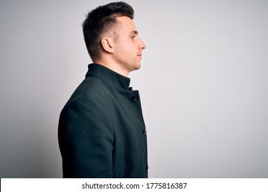 Young Handsome Business Mas Wearing Elegant Winter Coat Standing Over Isolated Background Looking To Side, Relax Profile Pose With Natural Face With Confident Smile.