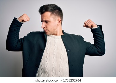 Young Handsome Business Mas Wearing Elegant Winter Coat Standing Over Isolated Background Showing Arms Muscles Smiling Proud. Fitness Concept.