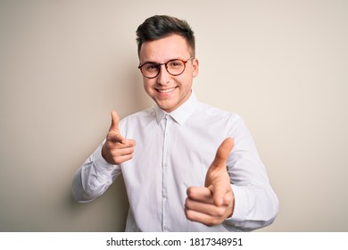 Young Handsome Business Mas Wearing Glasses And Elegant Shirt Over Isolated Background Pointing Fingers To Camera With Happy And Funny Face. Good Energy And Vibes.