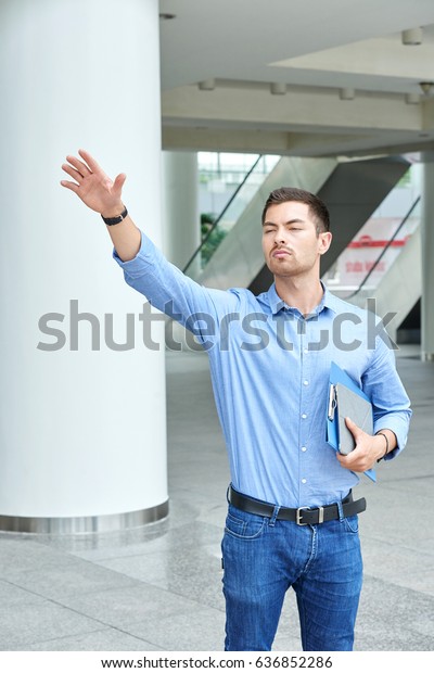 Young handsome\
businessman catching taxi