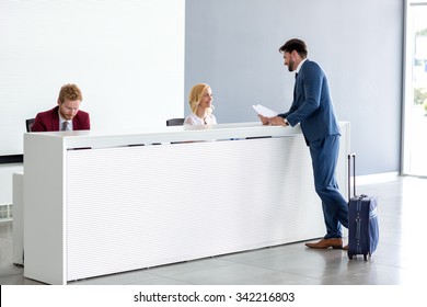 Young handsome businessman flirting with female receptionist