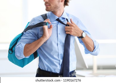 Young Handsome Businessman Holding Fitness Bag In Office. Gym After Work