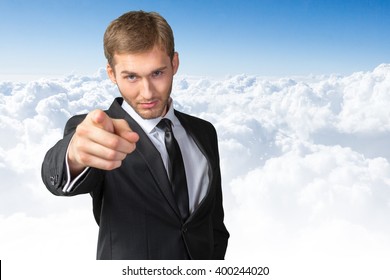 Young handsome businessman pointing on you