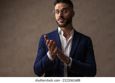 Young Handsome Businessman Rubbing His Palms And Looking Away With A Weird Look On His Face