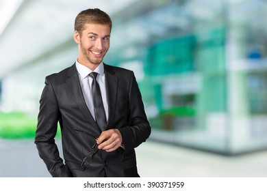 Young handsome businessman smiling - Shutterstock ID 390371959