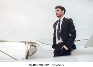 Young Handsome Businessman Is Standing Near Private Plane. Confident And Successful Man In Airport.