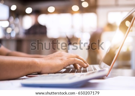Young handsome businessman using laptop for search information his work at cafe