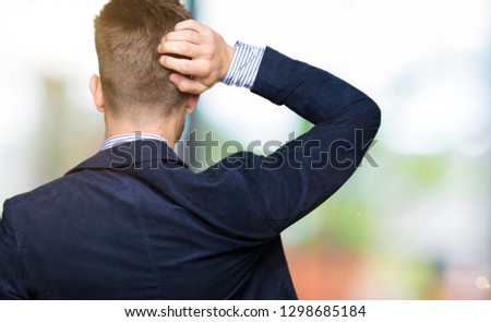 Young handsome bussines man Backwards thinking about doubt with hand on head