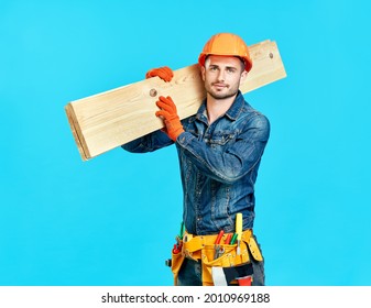 Young handsome carpenter hold lumber on his shoulders over blue background looking to camera - Powered by Shutterstock