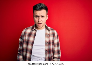 Young Handsome Caucasian Man Wearing Casual Modern Shirt Over Red Isolated Background In Shock Face, Looking Skeptical And Sarcastic, Surprised With Open Mouth