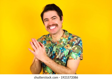 Young Handsome Caucasian Man Wearing Hawaiian Shirt Against Yellow Background, Feeling Happy, Smiling And Clapping Hands, Saying Congratulations With An Applause.
