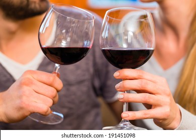 Young Handsome Couple Drinking Red Wine At Home