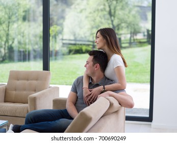 young handsome couple enjoys hugging on the sofa in their luxury home villa - Shutterstock ID 700690249