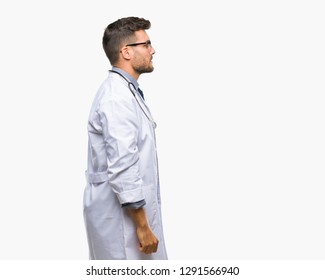 Young Handsome Doctor Man Over Isolated Background Looking To Side, Relax Profile Pose With Natural Face With Confident Smile.