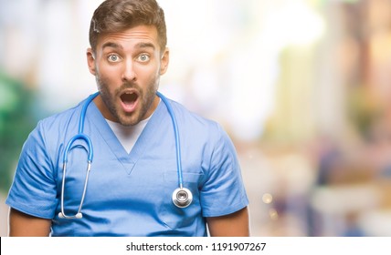 Young Handsome Doctor Nurse Man Over Isolated Background Afraid And Shocked With Surprise Expression, Fear And Excited Face.