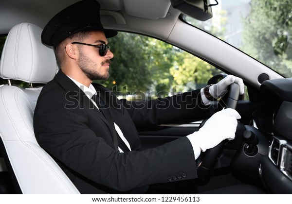 Young
handsome driver in luxury car. Chauffeur
service
