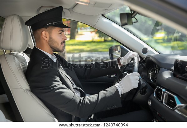 Young\
handsome driver in luxury car. Chauffeur\
service