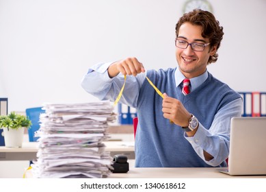 Young handsome employee unhappy with excessive work  