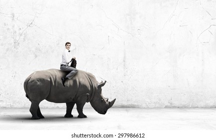 Young Handsome Fearless Man Riding Huge Rhino