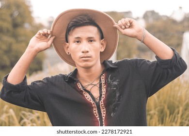 A young handsome Filipino man in a boho style polo shirt and hat. Casual portait, outdoor scene. - Shutterstock ID 2278172921