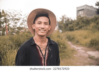 A young handsome Filipino man in a boho style polo shirt and hat. Casual portait, outdoor scene. - Shutterstock ID 2278172923