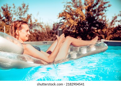 Young Handsome Fit Woman In Bikini Holding Beer Can While Floating On The Blue Pool Water And Relaxing. Copy Space