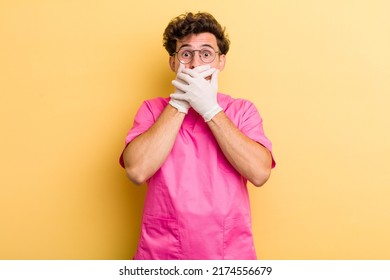 young handsome guy covering mouth with hands with a shocked. nurse concept