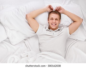 Young Handsome Happy Man Waking Up On Bed, Top View