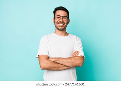 young handsome hicpanic man looking like a happy, proud and satisfied achiever smiling with arms crossed - Powered by Shutterstock