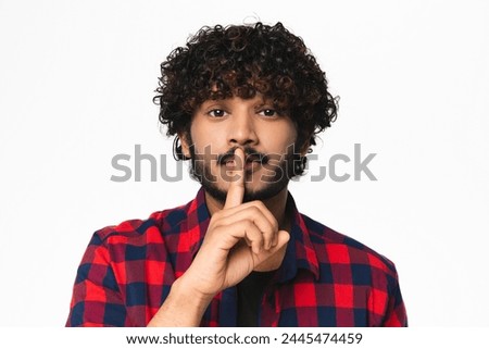 Young handsome Hindi man in casual clothes finger on lips isolated over white background. Attractive Indian boy with silent gesture, hushing , having secrets
